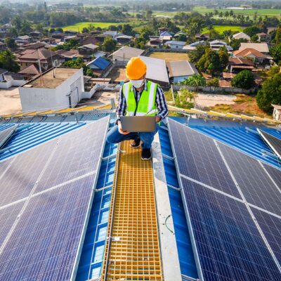 Operatore collauda l'impianto fotovoltaico appena installato su un tetto di un edificio